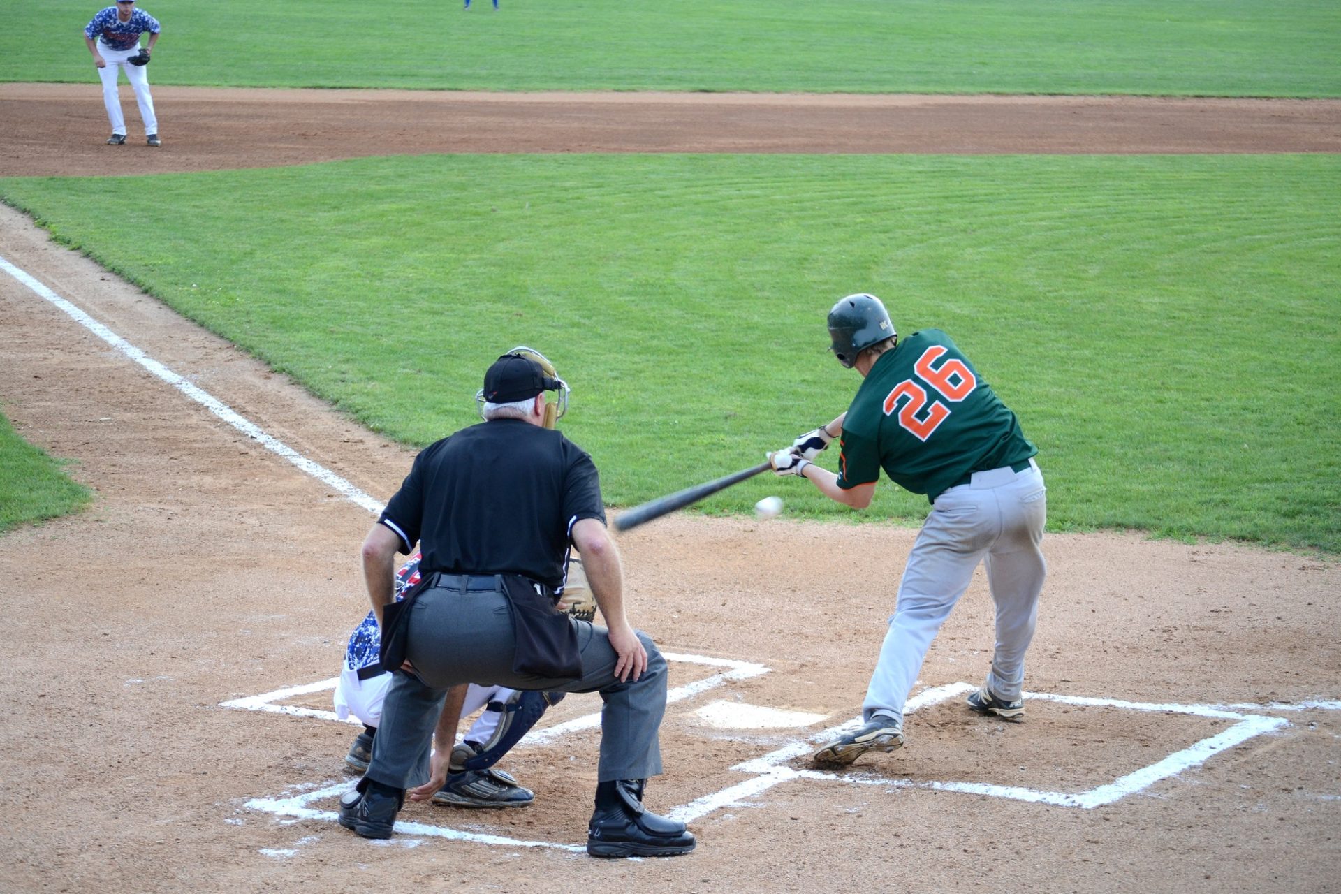 minor-league-baseball-team-playing-baseball-game-with-umpire-batter-hits-the-ball-with-baseball-bat-e1653456282431.jpg